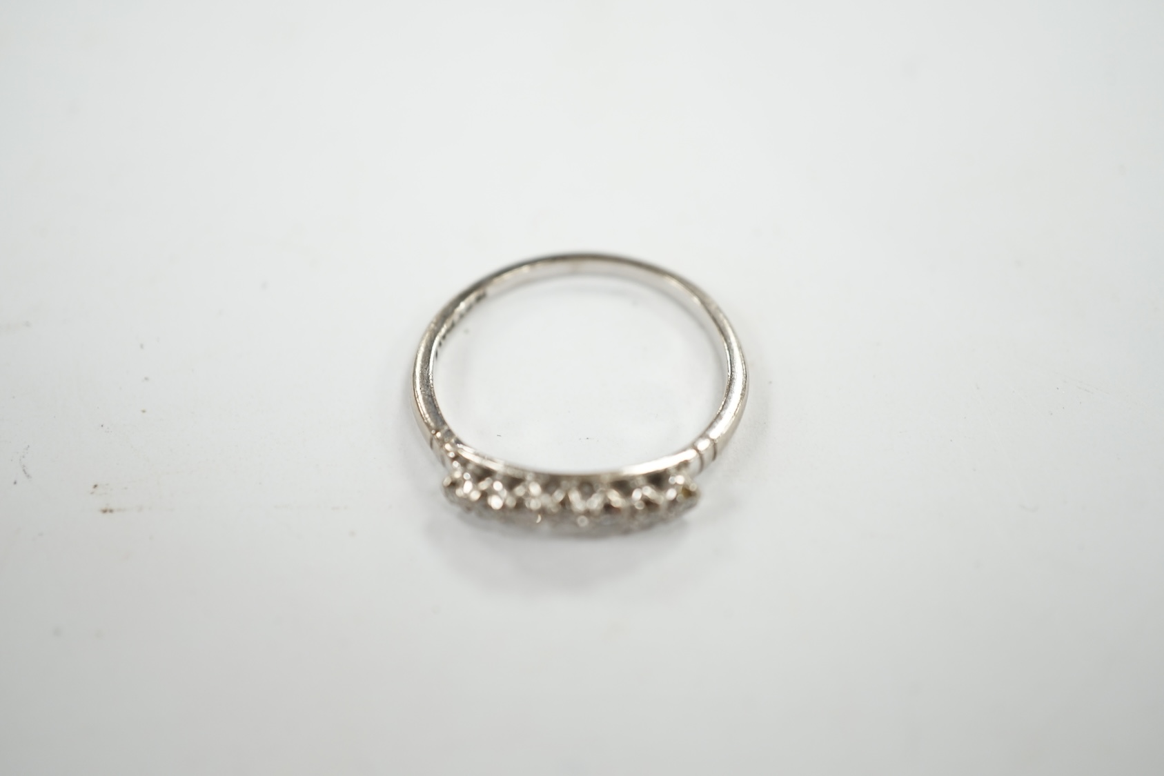 An 18ct, plat and seven stone diamond chip set 'chevron' half hoop ring, size O, gross weight 2.5 grams. Condition - fair